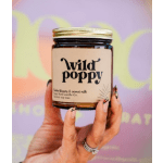 Hand holding a labeled candle jar with a gold lid