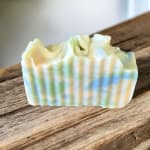 A small pastel-striped soap bar on a wooden surface