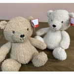 Two plush teddy bears sitting on a wooden surface