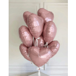 Cluster of pink heart-shaped balloons tied with white ribbons