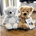Two plush teddy bears sitting on a wooden table