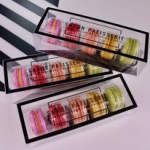 Three boxed sets of colorful macarons arranged diagonally
