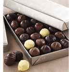 Box of assorted chocolates with a few pieces outside the box