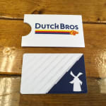Two branded gift cards on a wooden table