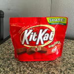 A red Kit Kat miniatures share pack sits on a countertop.