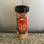 A clear plastic jar of Utz Pub Mix snack mix with a black lid