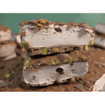 Stacked pieces of pistachio nougat candy with chocolate coating