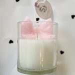 Pink flower-shaped candle in a clear glass container