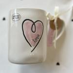 White ceramic mug with a pink heart and the word love