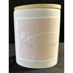 White candle in a glass jar with a wooden lid and pink label