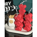 Heart-shaped red candles and a box of matches on a tray