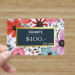 Hand holding a floral $100 gift card
