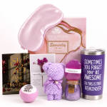 Pink gift set with a sleep mask, candle, soap, bath bomb, and teddy bear.