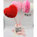 Heart-shaped rose arrangements on striped sticks in a gift box