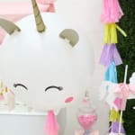 Unicorn party decoration with a large white unicorn face and pastel tassels