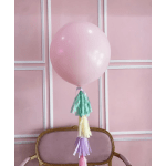 Pink balloon with multicolor tassels against a pink paneled wall
