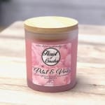 Pink scented candle in a frosted glass jar with a gold lid