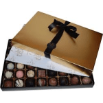 Box of assorted chocolates with a gold lid and black ribbon