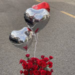 Red roses with two heart-shaped balloons on a street