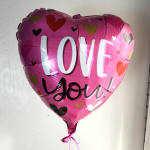 Pink heart-shaped balloon with the words "LOVE you"