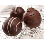 Three chocolate truffles on a white surface