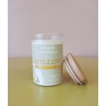 A scented candle in a glass jar with a wooden lid beside it