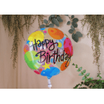 Colorful Happy Birthday balloon against a beige wall