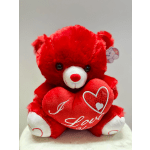 Red teddy bear holding a heart-shaped pillow