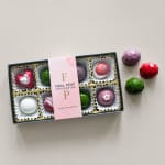 Box of assorted chocolates with a pink label and loose candies beside it