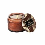 Brown scented candle in a glass jar with a patterned lid