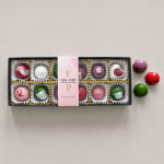 Box of assorted chocolates with colorful faceted candies beside it