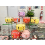 Assorted scented candles in glass jars on a display stand