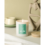 Lit scented candle in a white glass jar with a green label