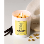 Lit vanilla scented candle in a white jar with a yellow label