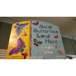 Decorative sign with colorful butterflies and the words Social Butterflies Land Here