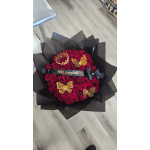 Bouquet of red roses wrapped in black paper with gold butterfly decorations