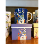 Blue mug with illustrated birds on a purple gift box