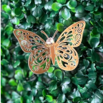 Decorative butterfly ornament on a dense green leaf backdrop
