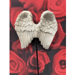 Pair of white angel wings ornament against a red rose background