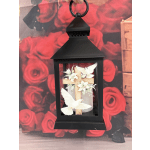 Black lantern with a cross, white flowers, and doves