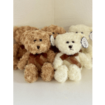 Plush teddy bears in tan and white with ribbon bows