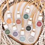 Assorted hanging fragrance bottles arranged in a wooden tray