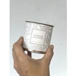 Hand holding a pumpkin cream pie scented candle tin
