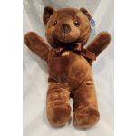 Brown teddy bear plush with a ribbon bow around its neck