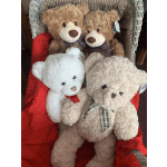 Four teddy bears in a wicker chair with a red blanket