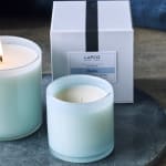 Set of two pale blue glass candles with white LAFCO box in the background