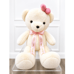 Cream teddy bear with a pink bow and ribbon sitting on a clear stand