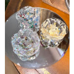 Three clear glass rose-shaped decorative pieces on a round mirror tray