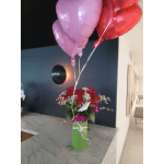 Red roses in a green vase with pink and red heart balloons