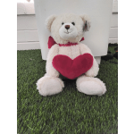 White teddy bear holding a pink heart